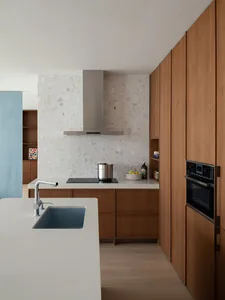 A modern residential kitchen with a white terrazzo countertop and minimalist design.