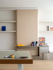 A modern living room with a wooden coffee table, yellow balls, and a bookshelf.