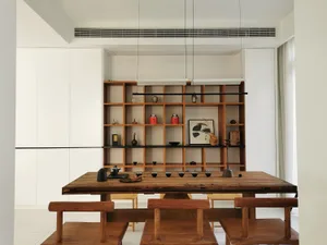 Modern living room featuring wooden furniture, glass surfaces, and metal accents.