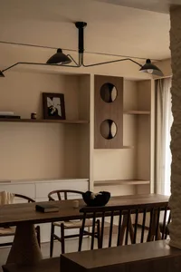 A modern minimalist dining room with wooden furniture and minimalist decor, featuring a long wooden table, chairs, and decora