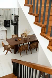 A modern interior design featuring a wooden dining table and chairs in a lounge-dining room setting.
