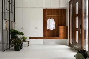 A modern minimalist entrance hall with wooden furniture and white walls.