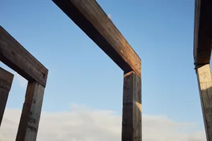 A close-up view of a wooden fence with metal brackets and bolts.
