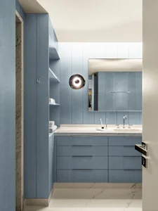 Minimalist bathroom with blue wooden cabinets, white countertop, and marble floor.