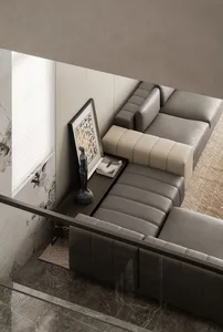 A modern living room featuring a couch upholstered in leather and positioned on a marble floor.