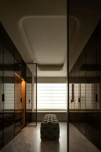 A modern minimalist closet with glass doors and a window seat