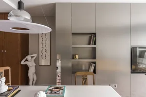 Modern minimalist interior featuring metal shelving units with books and decorative items.