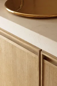A minimalist interior space with a wooden cabinet and metallic tray on a concrete countertop.