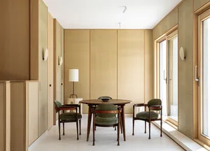 A modern dining room with a wooden table and velvet chairs.
