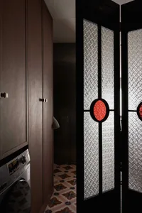 Modern interior with glass split door and patterned tiled floor.