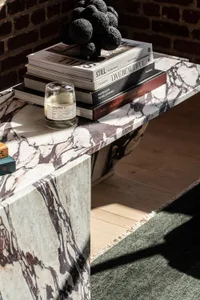 A modern marble coffee table adorned with books in a cozy indoor setting.
