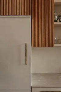 Modern minimalist kitchen featuring wooden cabinets and concrete countertops.