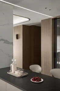 Modern minimalist kitchen featuring marble countertops and wooden cabinets.