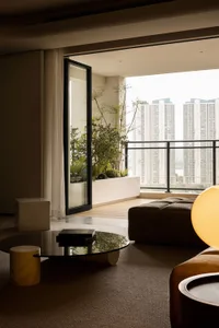 A modern minimalist living room featuring a glass door leading to a balcony.