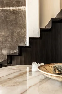 Modern staircase with metallic and wooden steps and a marble floor.