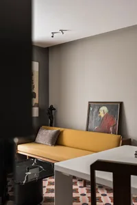 Modern living room featuring a yellow sofa, marble side table, and abstract wall art.