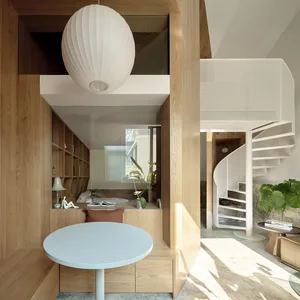 A minimalist interior design featuring wood and metal elements, with a circular table, bookshelf, and spiral staircase.