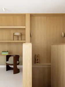 A minimalist interior space featuring wooden furniture and shelving.