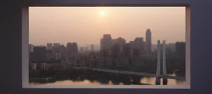 A cityscape view during sunset, featuring modern buildings made of concrete, glass, and steel.