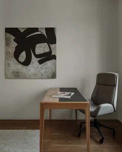 Minimalist design workstation featuring wood desk and gray upholstered chair.