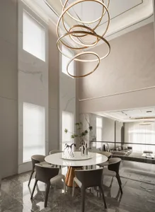 Modern dining room with a round marble table and six chairs, illuminated by a unique circular lighting fixture.