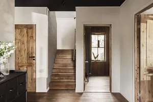 A modern interior design featuring wooden stairs leading to a different level within a residential or commercial building.