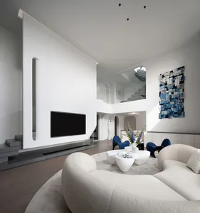 Contemporary living room with concrete walls and wooden furniture, featuring a circular sofa, coffee table, and blue accents.