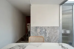 Modern residential space featuring a marble surface and cove lighting.