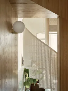 A modern staircase with a metallic perforated screen, featuring sleek design and minimalist aesthetic.