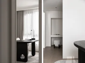 Modern minimalist residential interior with white walls, wood floor, and black desk.