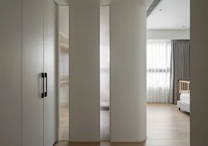 Modern minimalist bedroom featuring white cabinets, glass-paneled doors, and wooden flooring.