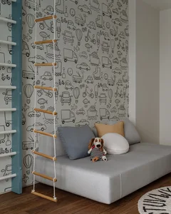 A minimalist interior design featuring a gray couch with pillows and a stuffed animal, against a patterned wall with various 