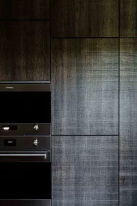 A modern interior with metallic tiles and sleek, dark cabinetry.