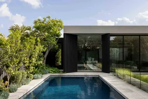 A modern residential building featuring glass and concrete materials.