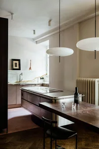 Modern residential kitchen featuring a marble countertop and wood accents