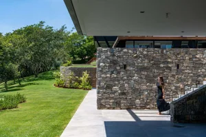 A modern building with stone walls and a landscaped garden.