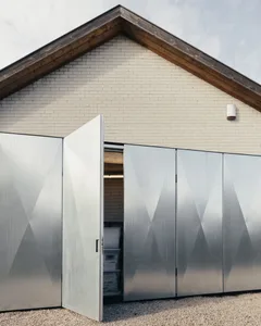 Modern building exterior featuring metallic panels and brick wall