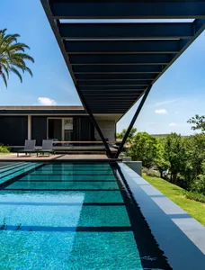 Modern exterior swimming pool with concrete, glass, and steel materials.