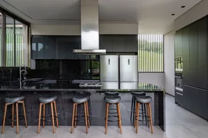 Modern kitchen featuring minimalist design, black marble countertops, and stainless steel appliances.