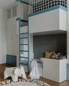A modern minimalist bedroom featuring a bunk bed with teal accents and a wooden floor with an alphabet rug.