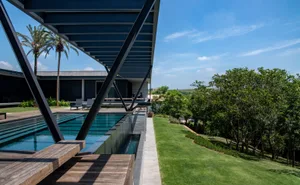 Modern metal structure with concrete swimming pool and landscape.