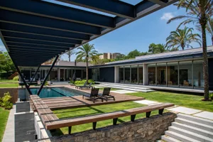 Modern residential exterior with metal roof and brick pool