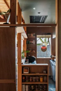 A kitchen showcasing industrial design elements with wooden furniture and various storage solutions.