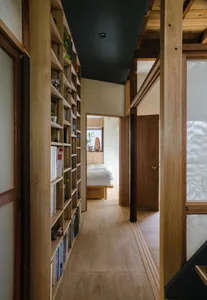 A minimalist bedroom with wooden shelves, white bedding, and a cozy atmosphere.