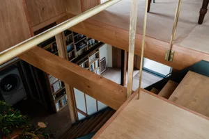 Minimalist interior design featuring a wooden staircase with glass railings.