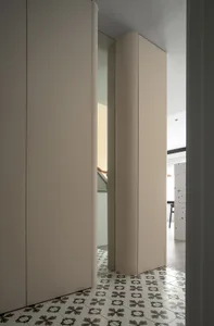 A minimalist interior space painted in neutral tones with a geometric pattern on the floor tiles.