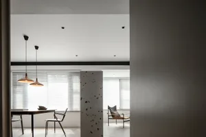 A minimalist modern dining space featuring concrete elements and contemporary furniture.
