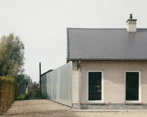 Front view of a modern residential building with brick and mortar exterior.