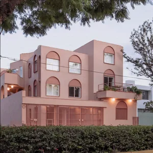 Modern residential building with concrete facade and arched windows.