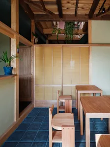 A modern restaurant interior with wooden furniture and plants on shelves.